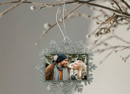 Silver glitter Christmas snowflake photo ornament hanging on a Christmas tree