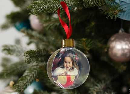 Gold glitter Christmas photo bauble hanging on a Christmas tree